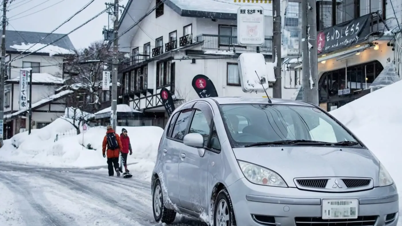 白馬レンタカーのコンパクトカー（4WD）と雪の白馬の街並み